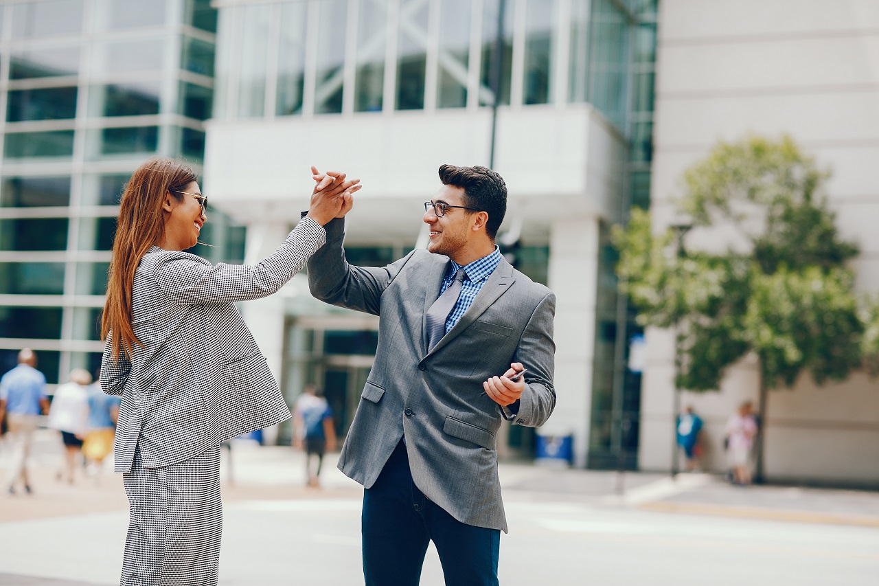 Two business partners celebrating after receiving a loan
