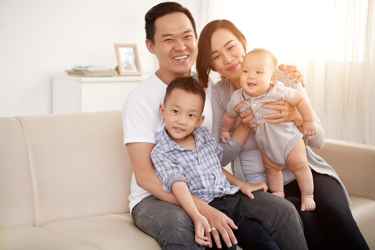 An Asian family smiling in their home