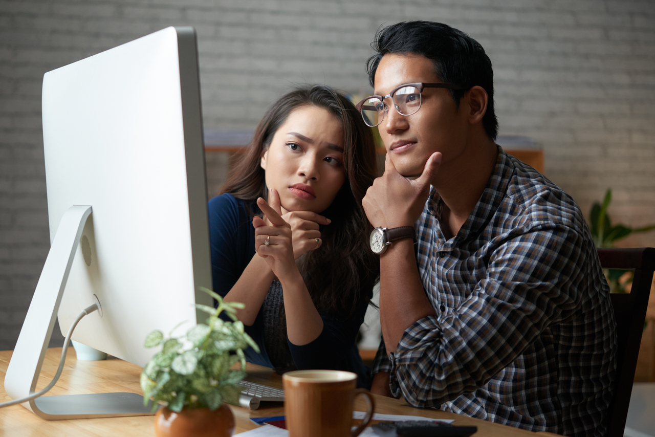 A couple on a computer checking if they're eligible for a loan