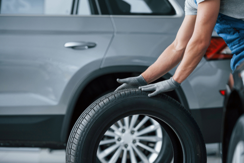 Mechanic holding a tire at the repair garage.
