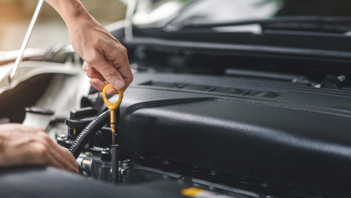 Close up of hands checking the oil level in the engine before a trip or journey