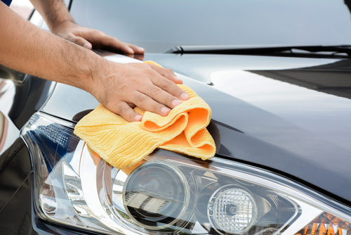 A man cleaning car with microfiber cloth