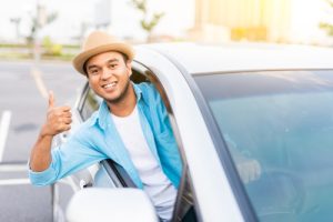 Man driving while giving a thumbs up