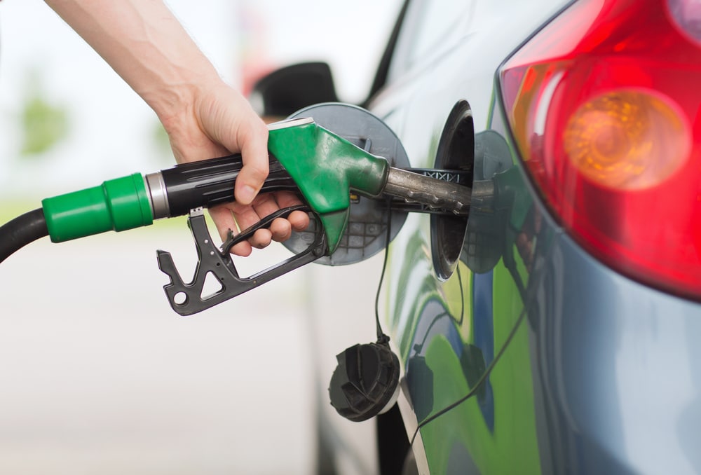 Close up shot of a person filling up the gas tank of a car. This is related to the topic of how to save money on car repairs.